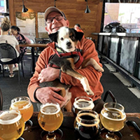 Instagram photo of dog and man drinking beer on Heathen patio
